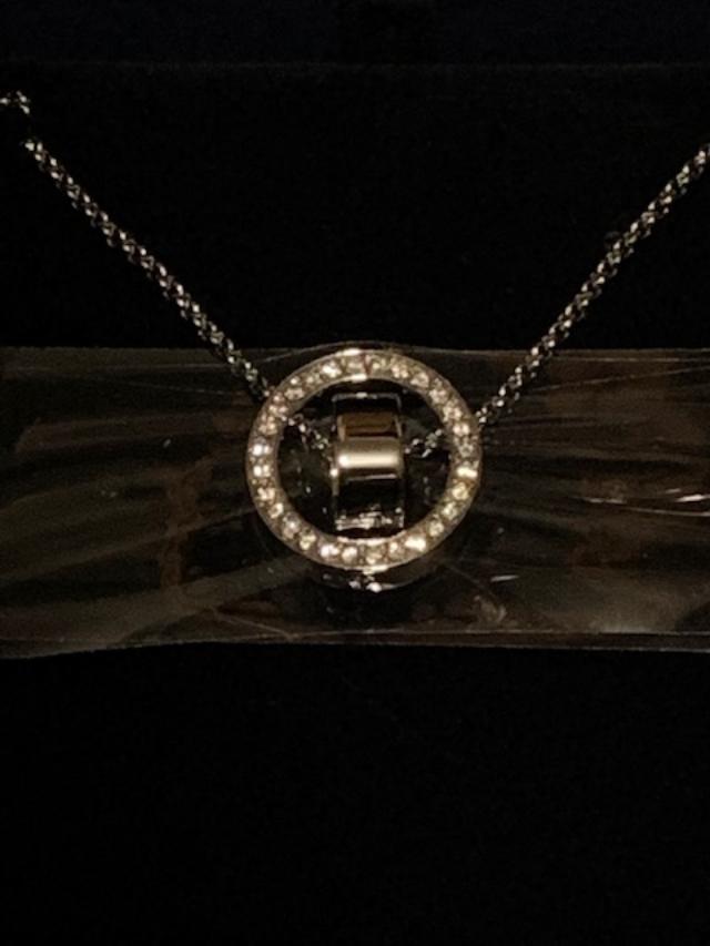 A circular pendant in the necklace