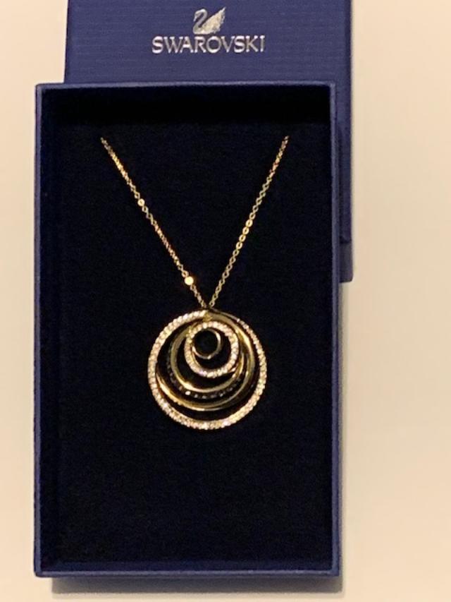A gold necklace with layers of circle pendant